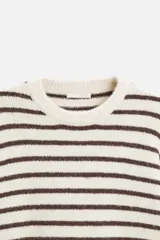 Sweater de punto color crudo con rayas horizontales marrones, de corte relaxed fit, cuello redondo y mangas largas con terminaciones en rib.