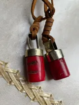 Collar con dije rectangular de nácar con borde dorado y tiento de cuero marrón.