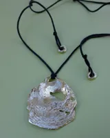 Collar con dije grande de bronce con forma de ostra y cordón de algodón ajustable color gris.