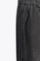 Pantalón de tiro medio con cintura elástica ajustable con cordones, bolsillos laterales ocultos en costura y pierna ancha. Confeccionado en hilatura con algodón y lyocell.