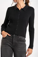 Cardigan negro de tejido de punto acanalado, con cuello polo, corte al cuerpo y cierre frontal con botones.