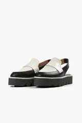 Mocasín slingback de cuero negro con detalle blanco en el empeine y base con plataforma dentada.