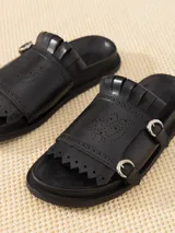 Sandalia negra de cuero vacuno con tiras anchas y suela elevada. Diseño calado en la capellada diseñado por Jazmin Chebar.