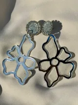 Aros de acrílico y resina en forma de flor, livianos y con un diseño moderno.