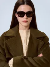 Tapado largo color verde militar, con cuello solapa, corte recto y cinturón para ajustar en la cintura.