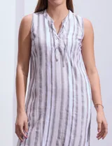 Vestido de algodón a rayas verticales azules y blancas, sin mangas, con cuello a la base y abertura central con lazo de ajuste.