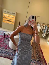 Top strapless con elástico en la parte superior e inferior, con estampado a cuadros vichy en blanco y negro.