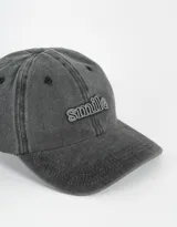 Gorra de denim color gris oscuro con bordado frontal de la palabra "Smile" en relieve.