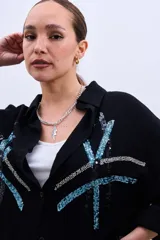 Camisa negra de corte amplio con botones y estampado de líneas con lentejuelas en color celeste y plateado.