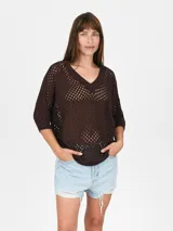 Buzo de tejido de punto calado color negro, con escote en V y mangas 3/4.