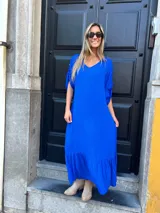 Vestido largo azul eléctrico con escote en V, mangas cortas con detalle de lazo y falda con volantes.