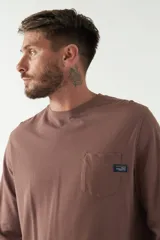 Remera color marrón de manga larga, con bolsillo en el pecho y logo de la marca en etiqueta sobre el bolsillo.