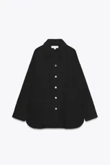 Sobrecamisa negra de denim de algodón, con cuello solapa, manga larga con puños, bolsillos de parche en el frente y cierre frontal con botones metálicos.
