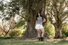 Blusa a rayas horizontales en tonos gris y blanco, con cuello y sisas en azul marino.