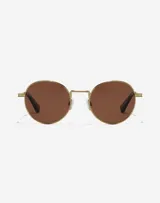 Lentes de sol Hawkers modelo Moma, unisex, con montura dorada de metal y lentes marrones polarizadas. Patillas de acetato con estampado carey.