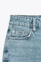 Pantalón de jean celeste de corte mom fit, tiro alto, largo tobillero y cinco bolsillos.