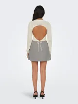 Sweater corto color crema, tejido a crochet con cuello redondo y mangas largas.