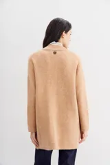 Tapado color beige de tejido de hilado suave y mullido, con calce relajado, mangas largas, cuello redondo y botones a tono.