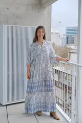 Vestido largo celeste y blanco con estampado geométrico, escote en V y mangas 3/4.