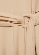 Mono color beige de viscosa y poliamida, con cuello redondo, manga corta, cinturón con hebilla y cierre de botón en la parte posterior.