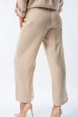 Pantalón palazo color beige con estampado animal print, cintura elastizada y lazo ajustable.