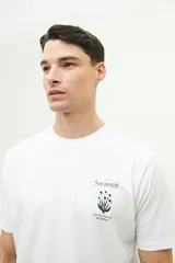 Remera blanca de manga corta con estampado pequeño en el pecho.