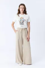 Pantalón beige de corte palazzo con cintura elastizada y cordón ajustable.