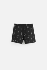 Bañador corto de hombre color negro con estampado de motivos playeros en blanco. Cintura elástica ajustable con cordón. Bolsillos laterales y trasero.