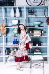 Zapato de tacón celeste con textura tejida, tira trasera y aplique de flor blanca en la punta.