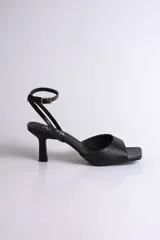 Sandalia negra de fiesta con punta cuadrada, tira delantera ancha y pulsera al tobillo con hebilla regulable.