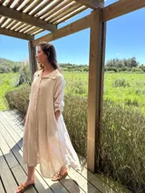 Vestido camisero amplio y largo de lino color azul, con botones de nácar, cuello camisero y bolsillos laterales.