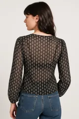 Blusa con estampado de paisley en blanco y negro, con escote redondo y mangas largas abullonadas.
