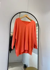Sweater coral de corte recto con cuello en pico y punto elástico en los puños.