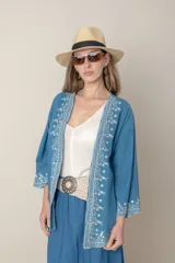 Chaqueta suelta de jean azul con bordados en hilo de seda color blanco.