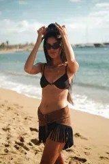 Top de bikini negro con aro y estribo metálico dorado en el centro.