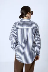 Camisa celeste con rayas verticales blancas, de corte clásico y manga larga.