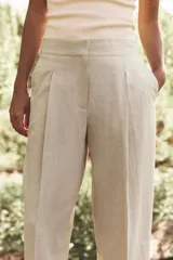 Pantalón azul marino de corte recto, confeccionado en lino. Presenta tiro alto, pinzas delanteras, bolsillos laterales y falsos bolsillos de vivo en la parte trasera.
