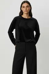 Buzo negro de terciopelo, con cuello redondo y manga larga.