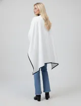 Ruana negra de tejido suave, con borde ribeteado en eco cuero y cierre frontal con botones metálicos dorados.