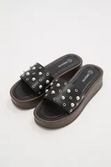 Sandalias de plataforma color negro con base marrón y apliques de tachas plateadas.