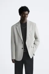 Blazer straight fit color gris claro confeccionado en tejido con viscosa. Tiene cuello con solapas de muesca, manga larga acabada en puño con botón, bolsillo de vivo en pecho, bolsillos de plastrón en cadera y bajo con aberturas en espalda. Cierre frontal de botonadura.