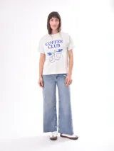 Remera rosa con estampado de labios rojos y texto con tipografía retro.