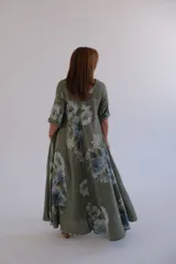 Vestido largo verde con estampado de flores azules, corte amplio y mangas 3/4.