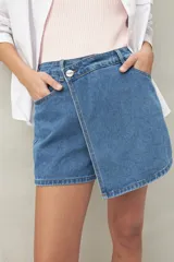 Short pollera de denim azul con corte asimétrico y cierre con botón.