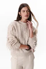 Sweater color beige de tejido de punto con cuello redondo y mangas largas con flecos.