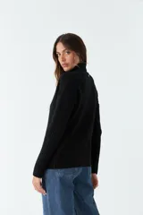 Sweater tejido negro de cuello alto y corte regular.