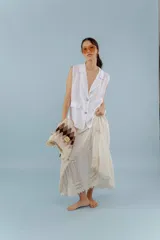 Chaleco color amarillo pastel de lino, sin mangas, con cuello solapa y cierre frontal con dos botones.