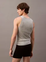 Pack de tres camisetas sin mangas Calvin Klein de algodón, con logo bordado en el dobladillo. Incluye una remera negra, una gris y una blanca.