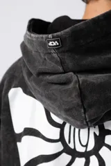 Buzo canguro negro con efecto gastado y estampa cuadrada con diseño abstracto en el pecho. Corte oversize con capucha y puños ajustados.