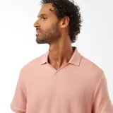 Remera rosa de punto de piqué con cuello en V y mangas cortas.